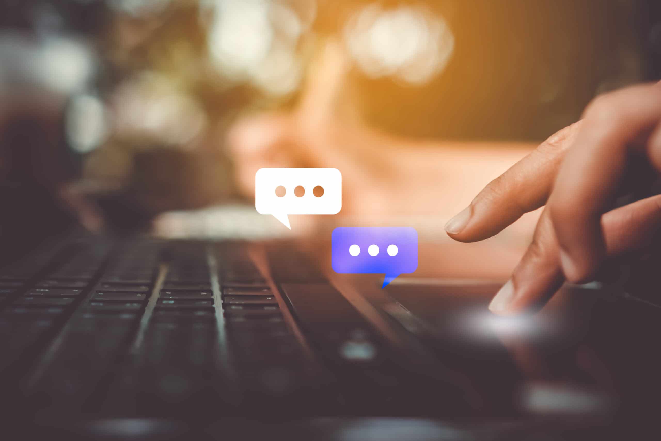 Hands typing on a laptop keyboard in a custom service chat box as part of a contact center experience