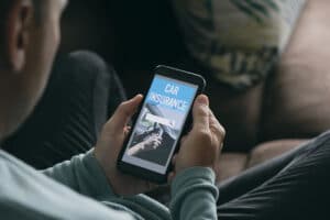 A man shops for car insurance on his phone - The future of insurance distribution