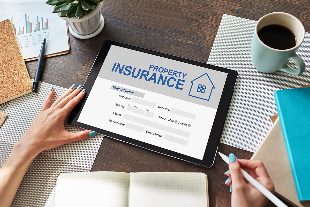 Woman completes online property insurance application on a tablet - The future of insurance distribution