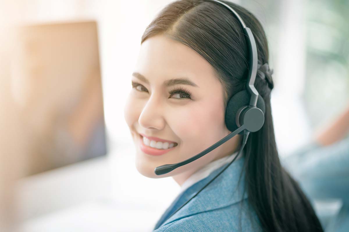 Smiling frontline employee in a contact centre wearing a headset