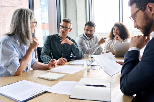 Business leaders collaborate to define accountabilities - a team of five gathers around a boardroom table