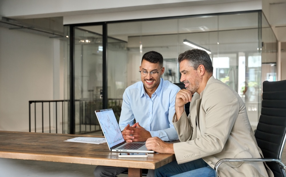 2 men looking at a computer in an office setting