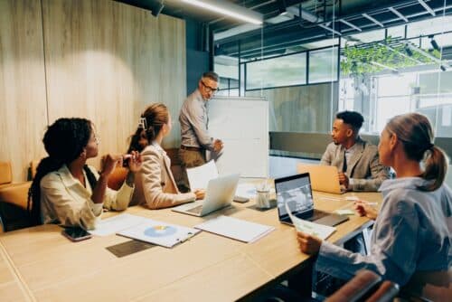 Leadership team working in a room with papers and laptops on the table.